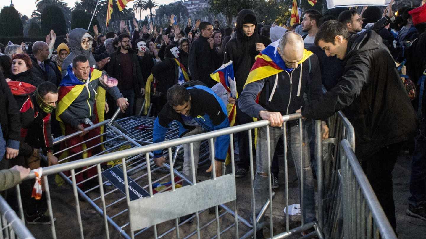 Manifestantes derriban las vallas de seguridad que rodean el Parlament.