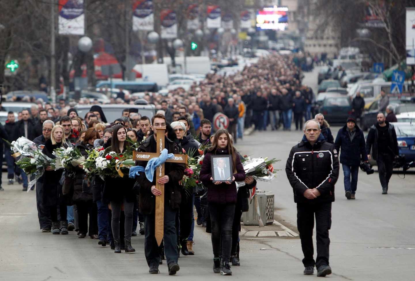 Residentes de la cuidad kosovar de Kosovska Mitrovica participan en una procesión de familiares y allegados en despedida del líder serbokosovar Oliver Ivanovic.