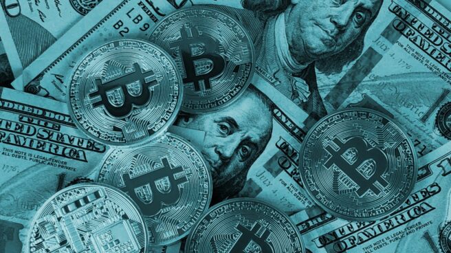 Representaciones de la moneda virtual bitcoin sobre billetes de dólar.