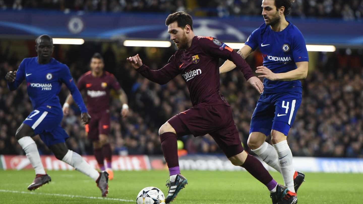 El jugador Cesc Fabregas (d) del Chelsea disputa un balón con el jugador Lionel Messi (c) del Barcelona hoy, martes 20 de febrero de 2018, durante su juego de la Liga de Campeones de la UEFA, entre el Chelsea FC y el FC Barcelona, en el estadio de Stamford Bridge de Londres (R.Unido).