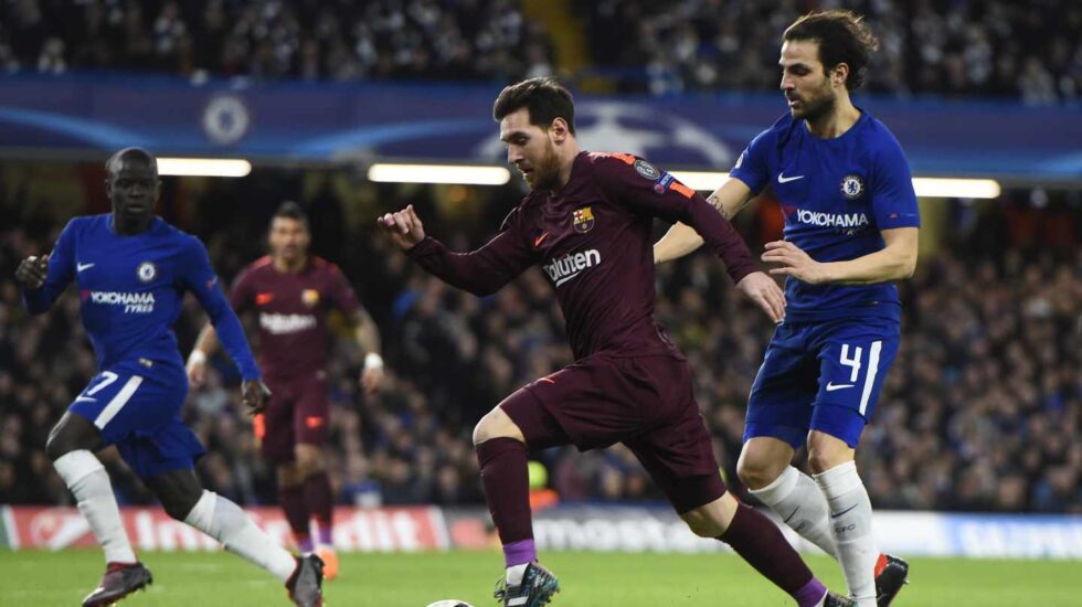 El jugador Cesc Fabregas (d) del Chelsea disputa un balón con el jugador Lionel Messi (c) del Barcelona hoy, martes 20 de febrero de 2018, durante su juego de la Liga de Campeones de la UEFA, entre el Chelsea FC y el FC Barcelona, en el estadio de Stamford Bridge de Londres (R.Unido).