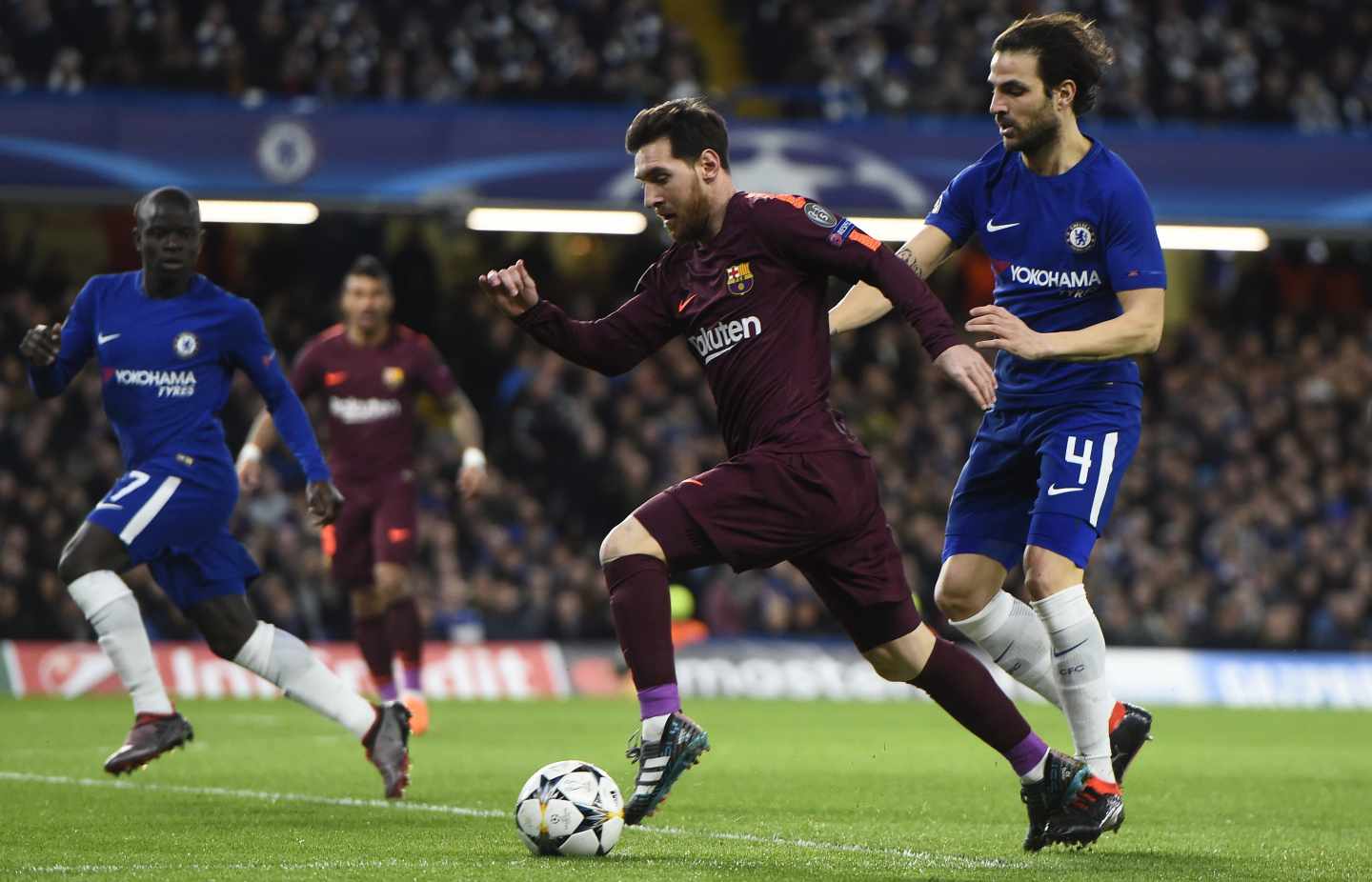 El jugador Cesc Fabregas (d) del Chelsea disputa un balón con el jugador Lionel Messi (c) del Barcelona hoy, martes 20 de febrero de 2018, durante su juego de la Liga de Campeones de la UEFA, entre el Chelsea FC y el FC Barcelona, en el estadio de Stamford Bridge de Londres (R.Unido).