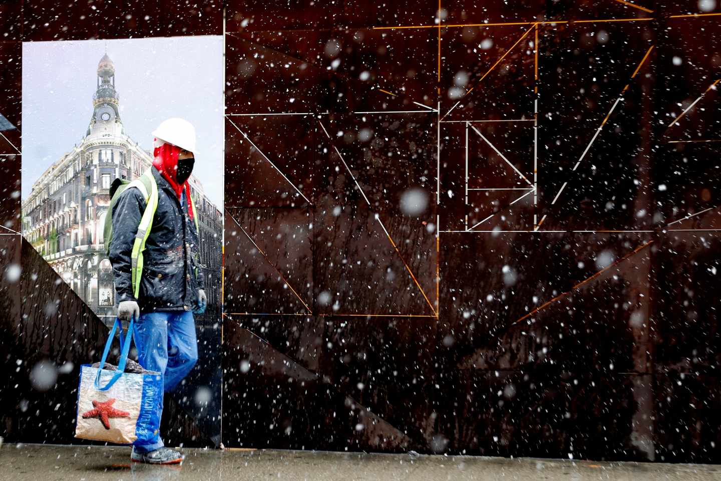 Un hombre camina bajo la intensa nevada caída esta mañana en el centro de la capital. La nieve que cae desde primera hora de la mañana en la Comunidad de Madrid ha cuajado en torno al mediodía en la capital, donde a estas horas el blanco es el color predominante en puntos como el parque de El Retiro y los alrededores del río Manzanares. La Ciudad Universitaria y el aeropuerto Adolfo Suárez Madrid-Barajas son otros de los rincones donde ha cuajado la nieve, mientras que en la Plaza Mayor, la Gran Vía o en la Puerta del Sol aún no lo ha hecho por el intenso tránsito de peatones y coches, y a la humedad de la calzada.