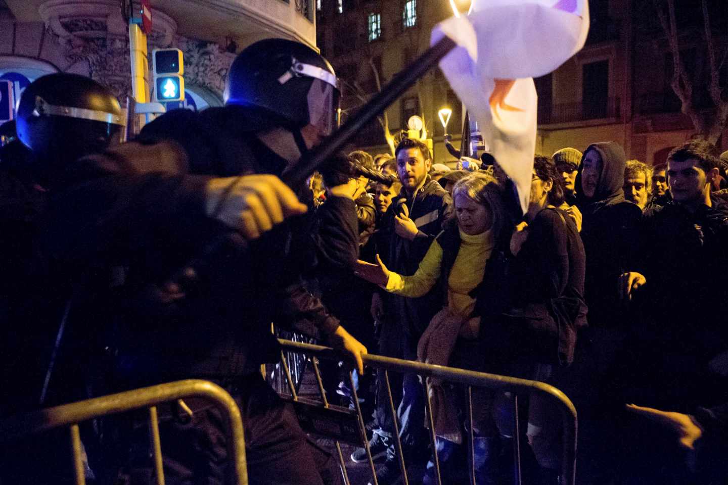 Un agente de los Mossos d'Esquadra recoloca una de las vallas que los manifestantes trataban de echar abajo.