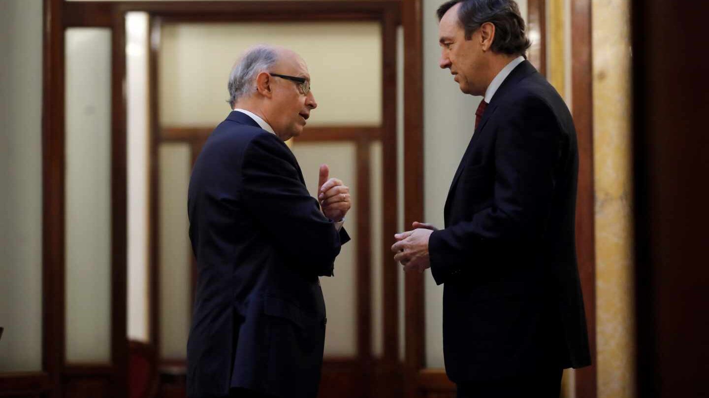 El ministro de Hacienda, Cristobal Montoro, y el portavoz parlamentario del PP, Rafael Hernando, en los pasillos del Congreso.
