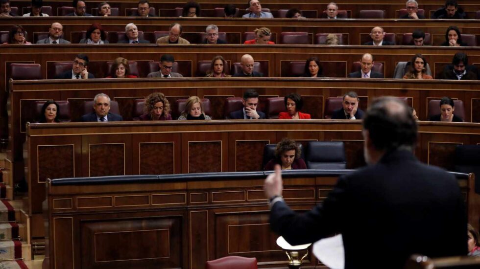 El presidente del Gobierno, Mariano Rajoy, de espaldas, durante su intervención en la sesión de control del Congreso.