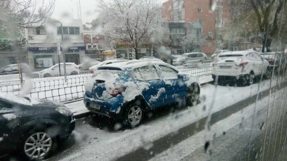 Un coche completamente nevado en Madrid.