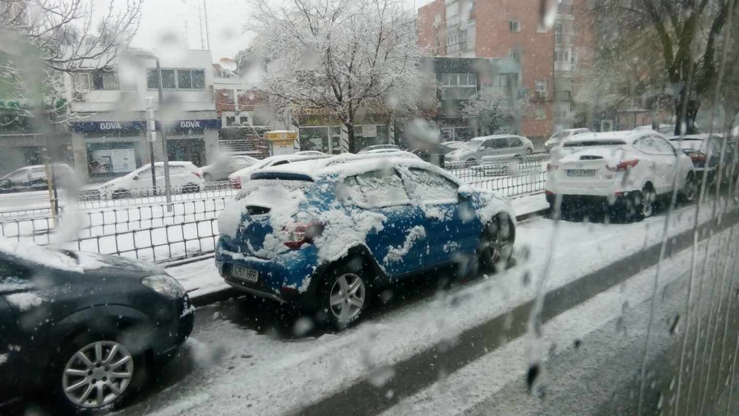 Un coche completamente nevado en Madrid.