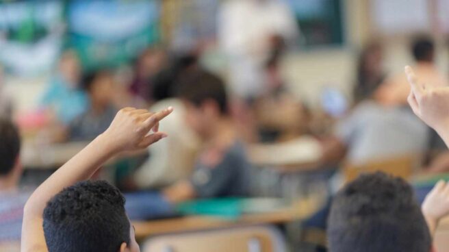 niños aula educación Cataluña Niños levantan la mano en un aula.