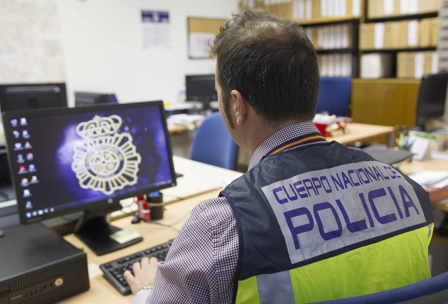 Un policía ante un ordenador. Un policía ante un ordenador.