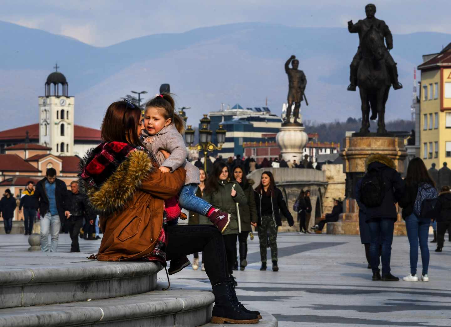 Viandantes en la plaza principal de Skopje, donde los gobiernos nacionalistas han erigido en los últimos años figuras mitológicas del antiguo reino de Macedonia para reclamar su herencia sobre el actual país.