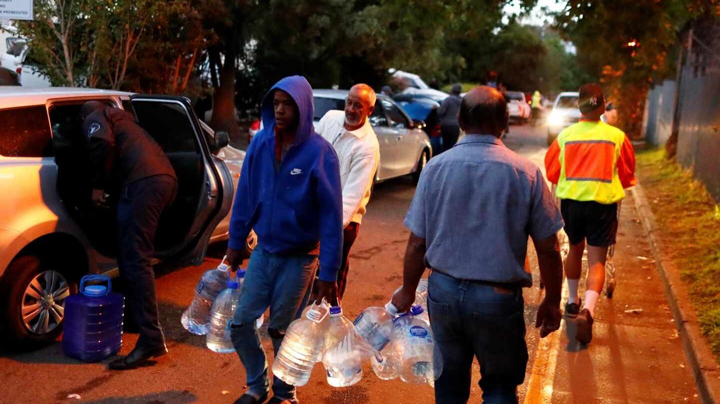 Los habitantes de Ciudad del Cabo, cargados de garrafas, acuden a los puntos de abastecimiento de agua repartidos por la ciudad.