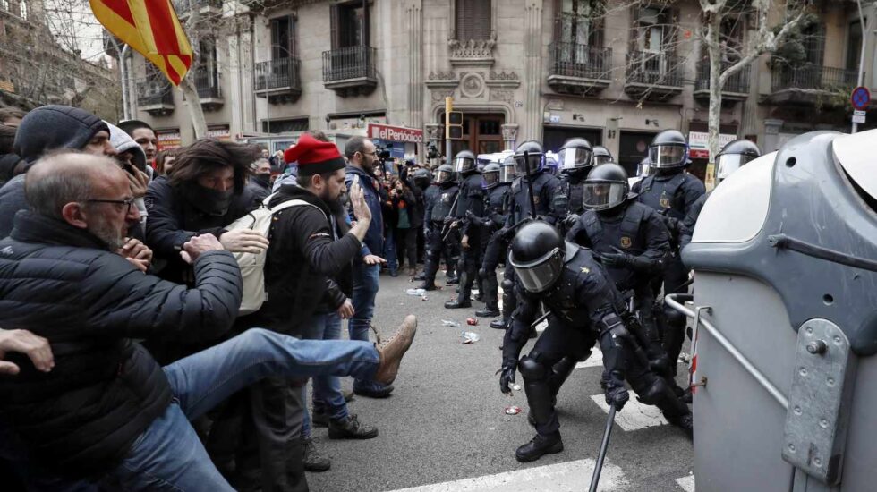 Miembros de los Mossos d´Esquadra impiden el paso de manifestantes en las inmediaciones de la Delegación del Gobierno en Cataluña, donde centenares de independentistas tratan de desbordar el cordón policial en protesta por la detención del expresidente catalán Carles Puigdemont.