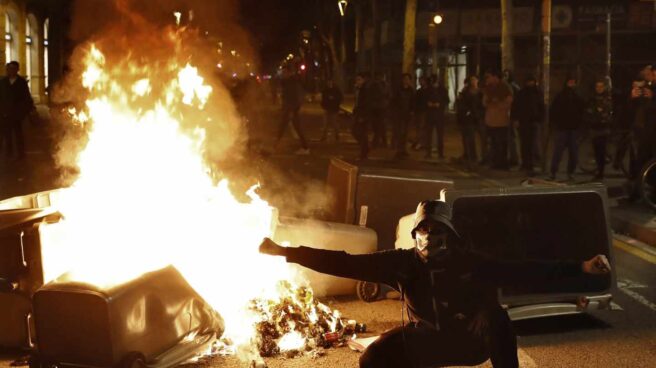 contenedores_barcelona_ardiendo Un manifestante, junto a uno de los contenedores incendiados en Barcelona durante los disturbios del 25 de marzo.