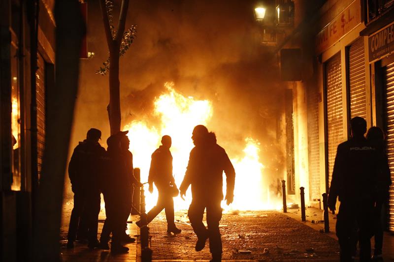 Violentos incendian mobiliario urbano en la noche de este jueves en el barrio madrileño de Lavapiés.