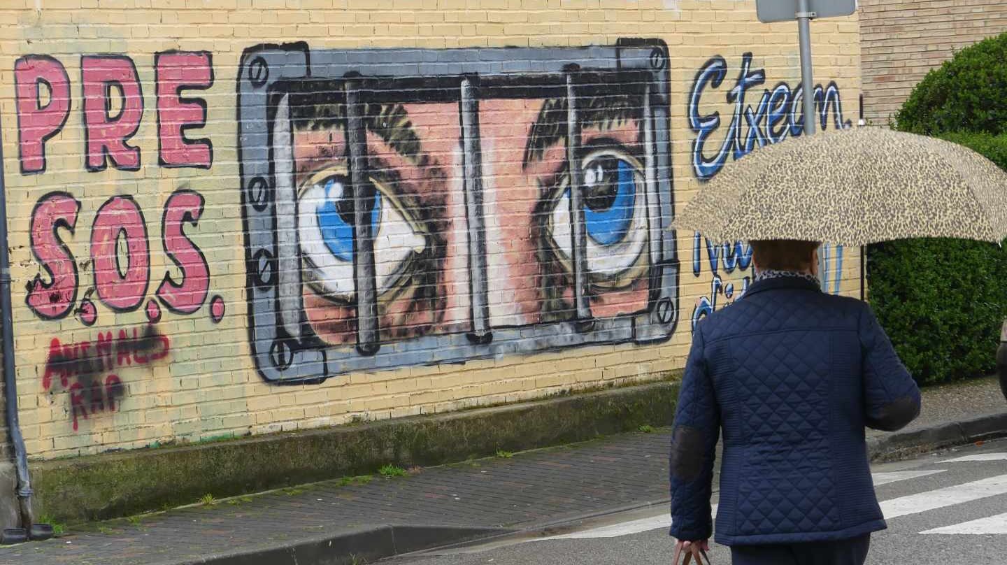 Una mujer pasa frente a un mural de apoyo a los presos de ETA en Alsasua.