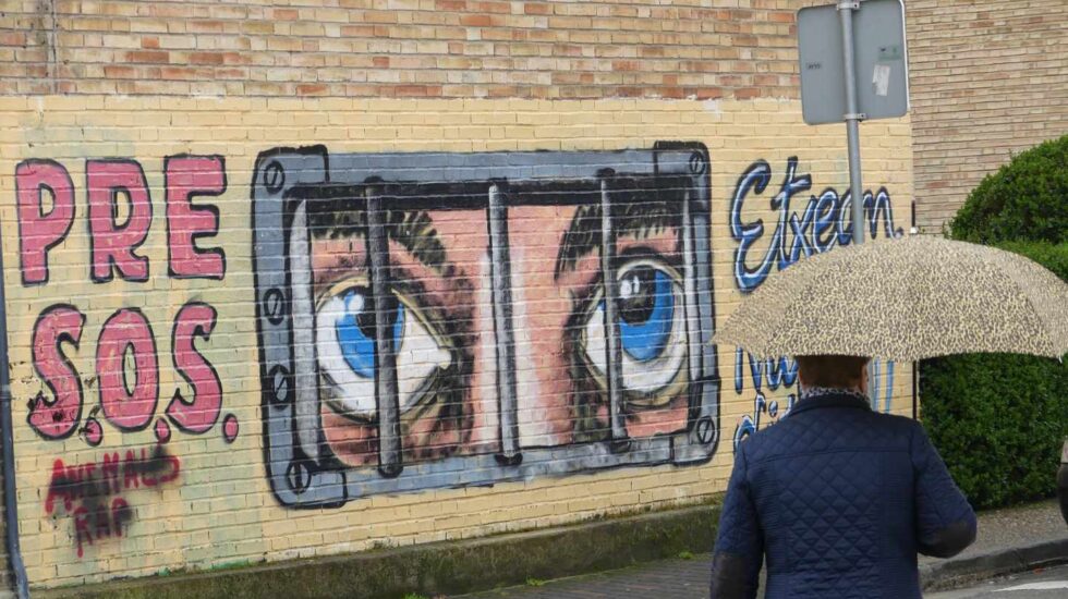 Una mujer pasa frente a un mural de apoyo a los presos de ETA en Alsasua.