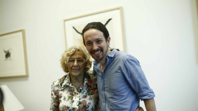 Manuela Carmena y Pablo Iglesias abrazados posando para una fotografía