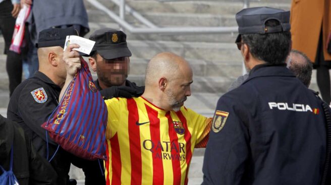 Agentes de policía registan a un aficionado. Agentes de policía registan a un aficionado.