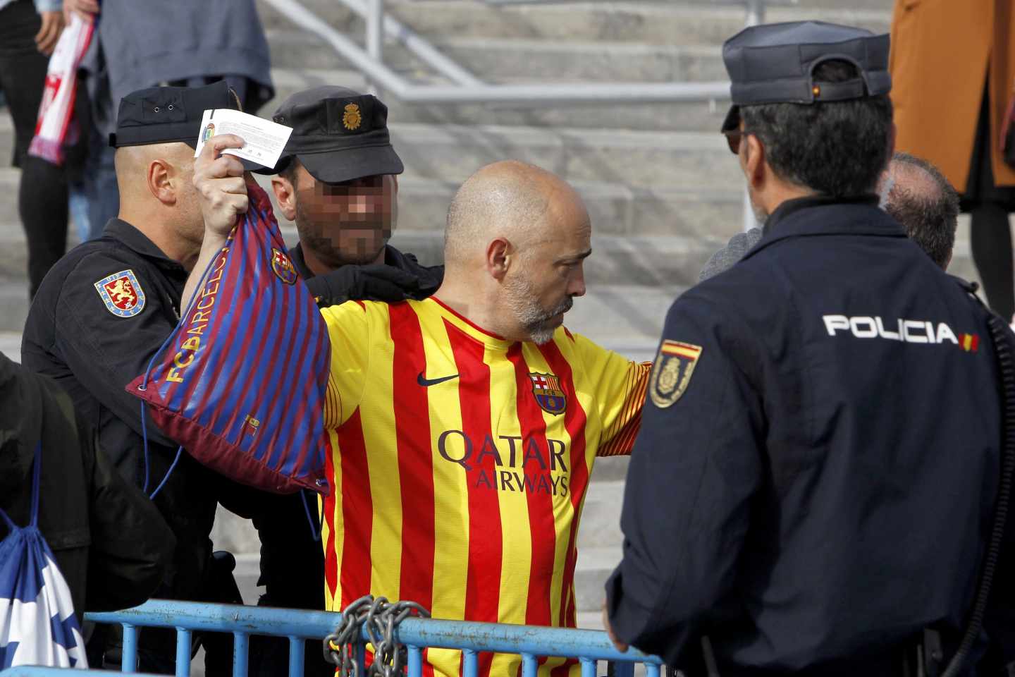 Agentes de policía registan a un aficionado.