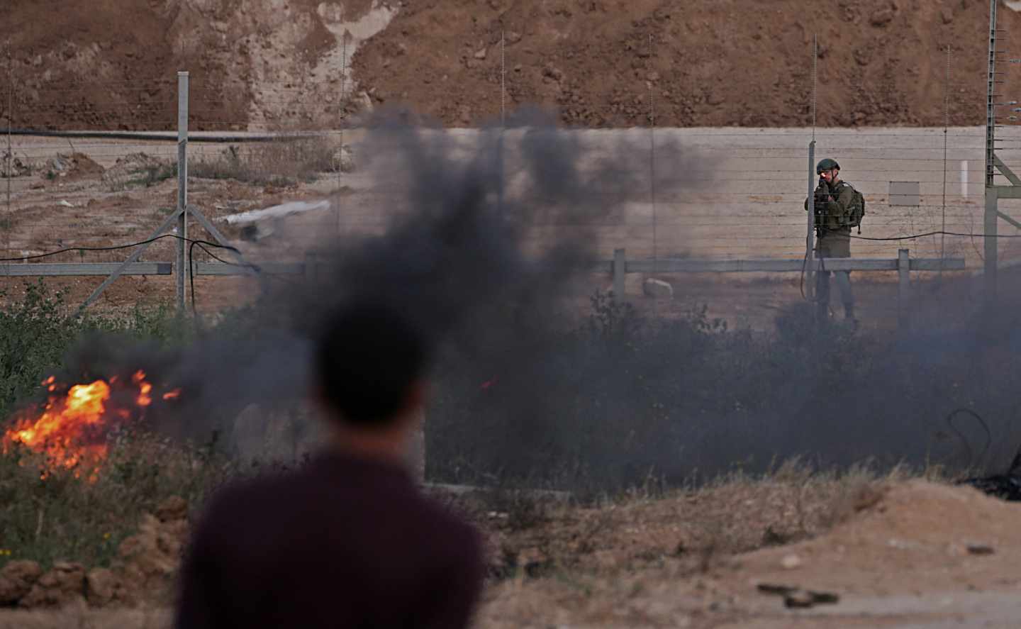 Un soldado israelí apunta a los manifestantes palestinos hoy, martes 3 de abril de 2018, durante los enfrentamientos con las tropas israelíes a lo largo de la frontera entre Israel y la Franja de Gaza, en el este de la Franja de Gaza. Los manifestantes planean reclamar el derecho de los refugiados palestinos en Medio Oriente a regresar a los hogares de los que huyeron en la guerra que rodeó la creación de Israel en 1948. EFE