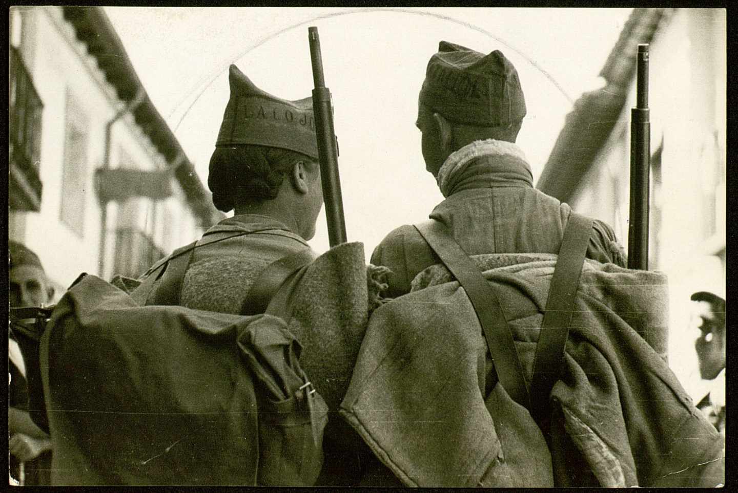 Dos milicianos de espaldas, armados, en dirección al frente, en Madrid, 1936. 