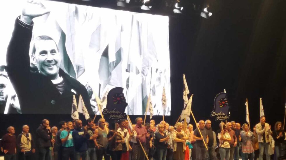 Presos de ETA son aplaudidos en el escenario del Bilbao Arena durante el acto de Sortu sobre una imagen de Arnaldo Otegi.