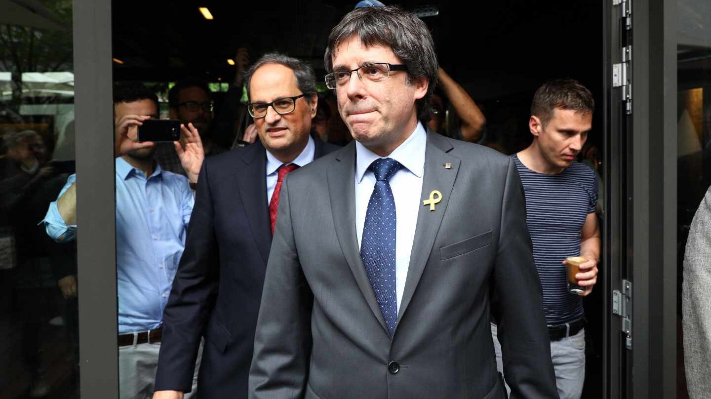 El recién elegido presidente de la Generalitat de Cataluña, Quim Torra (c-izq), y su predecesor, el expresidente regional catalán Carles Puigdemont (c-dcha), llegan juntos a una rueda de prensa convocada en el Hotel Sana en Berlín (Alemania) hoy, 15 de mayo de 2018