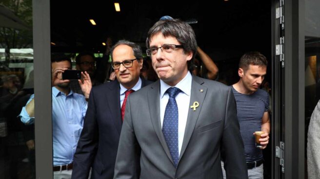 El recién elegido presidente de la Generalitat de Cataluña, Quim Torra (c-izq), y su predecesor, el expresidente regional catalán Carles Puigdemont (c-dcha), llegan juntos a una rueda de prensa convocada en el Hotel Sana en Berlín (Alemania) hoy, 15 de mayo de 2018