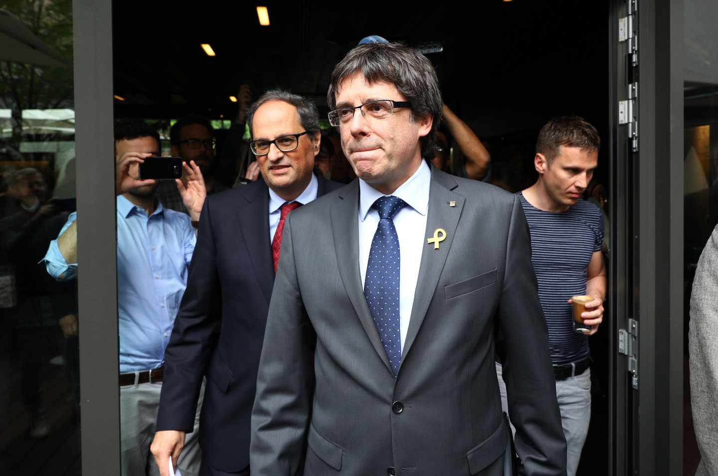 El recién elegido presidente de la Generalitat de Cataluña, Quim Torra (c-izq), y su predecesor, el expresidente regional catalán Carles Puigdemont (c-dcha), llegan juntos a una rueda de prensa convocada en el Hotel Sana en Berlín (Alemania) hoy, 15 de mayo de 2018