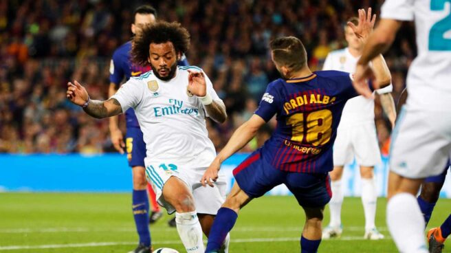 El defensa brasileño del Real Madrid, Marcelo (i), intenta superar la entrada del jugador del FC Barcelona, Jordi Alba, durante el encuentro correspondiente a la jornada 36 de primera división que disputan esta noche en el estadio del Nou Camp.