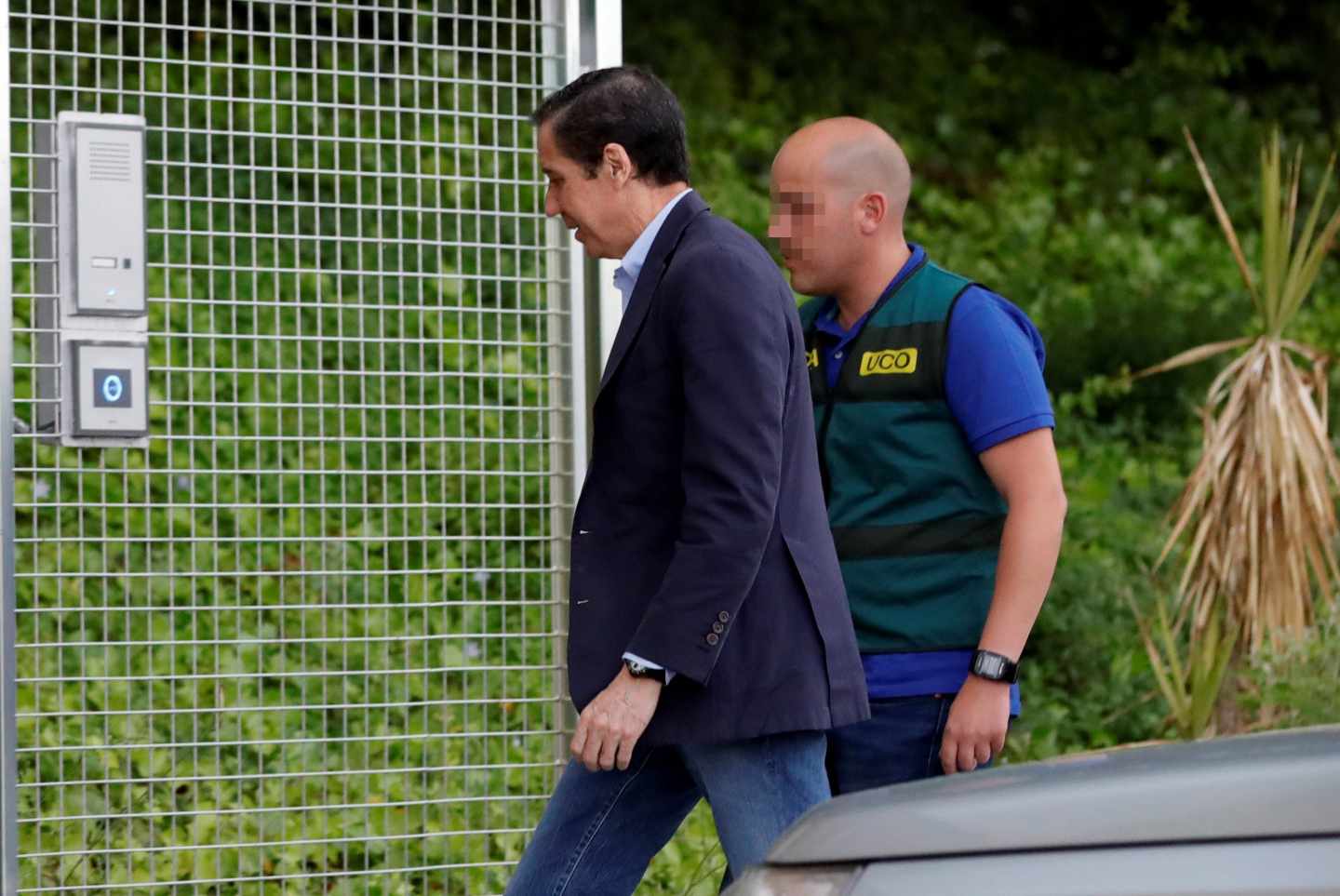 Eduardo Zaplana, trasladado a los calabozos por un agente de la UCO de la Guardia Civil.