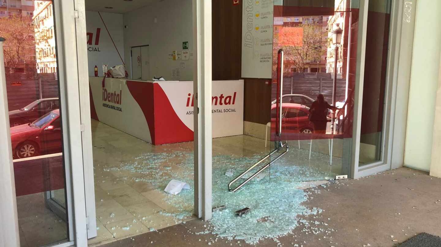Imagen de la puerta de cristal derribada en la clínica de iDental en Valencia.