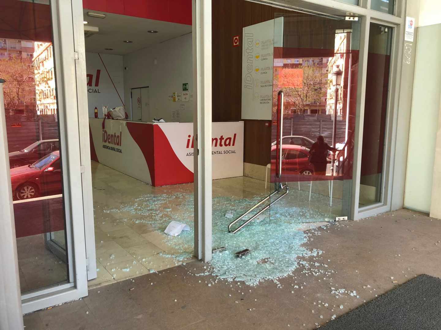 Imagen de la puerta de cristal derribada en la clínica de iDental en Valencia.