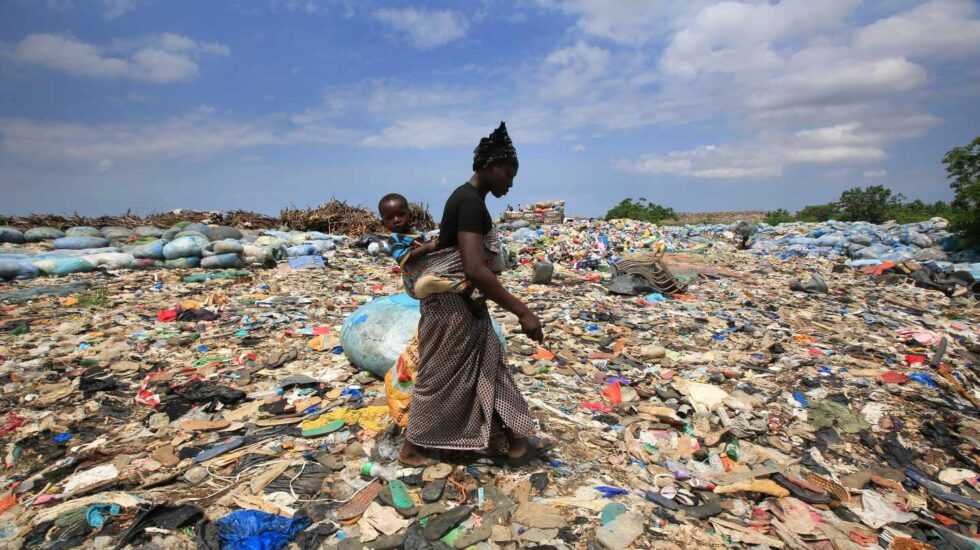Una mujer rebusca botellas de plástico en el basurero de Akouedo, en Abiyán (Costa del Marfil) el 29 de mayo de 2018.