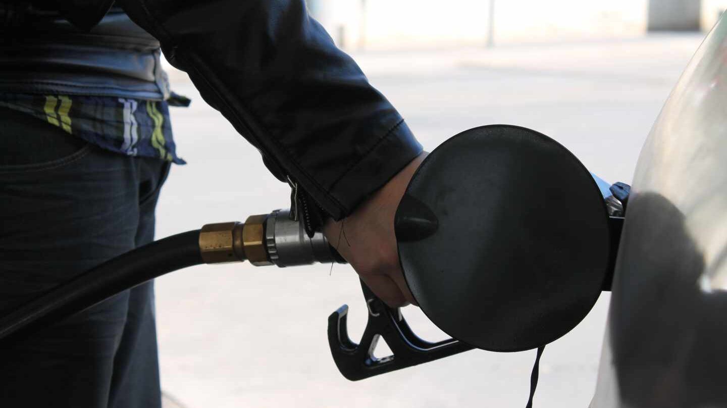 Un conductor llena el depósito de su coche en una gasolinera.