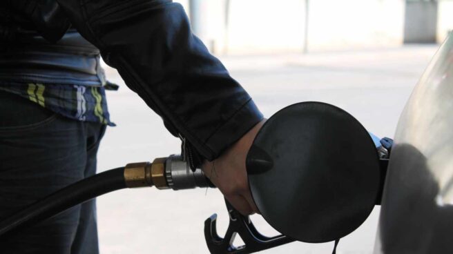 Un conductor llena el depósito de su coche en una gasolinera.