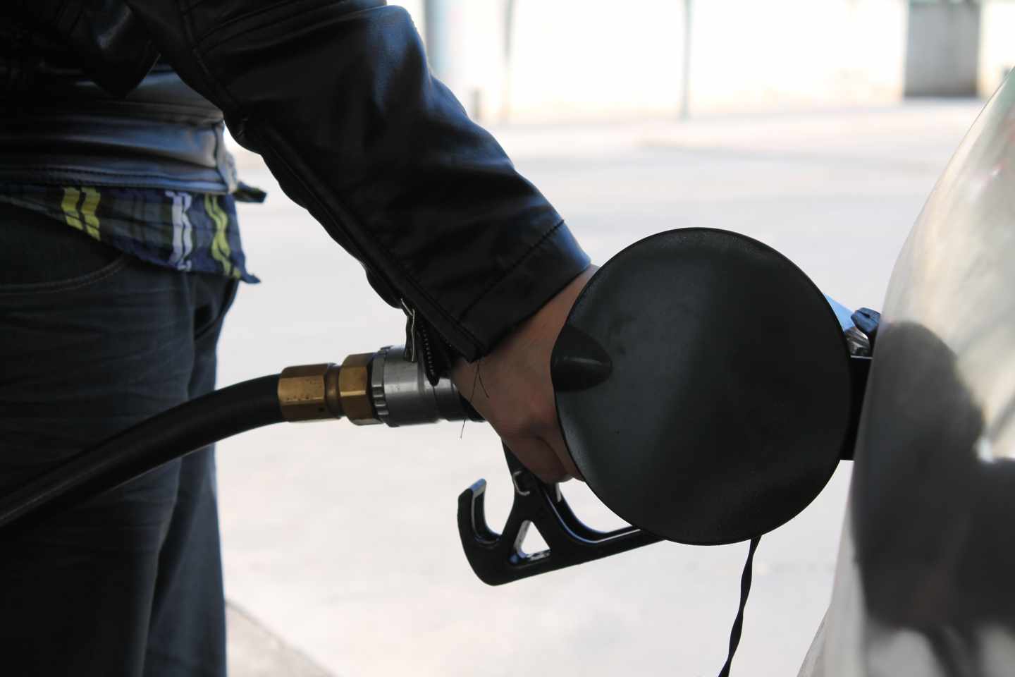 Un conductor llena el depósito de su coche en una gasolinera.