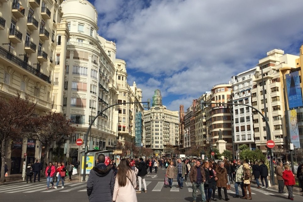 Personas paseando por una calle de Valencia.