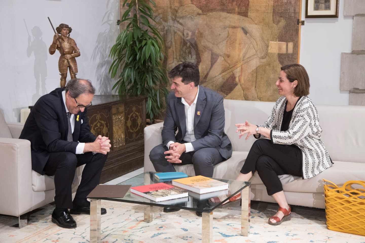 El presidente de la Generalitat, Quim Torra (i), conversa con el presidente del grupo parlamentario de ERC, Sergi Sabrià (c), y la portavoz, Anna Caula (d).