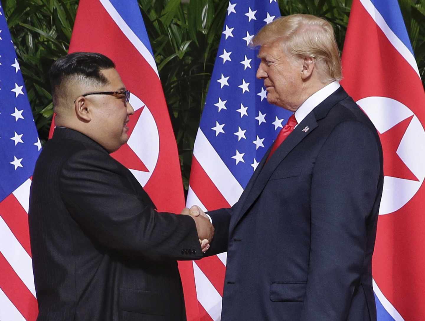 Kim Jong-Un y Donald Trump dándose la mano.