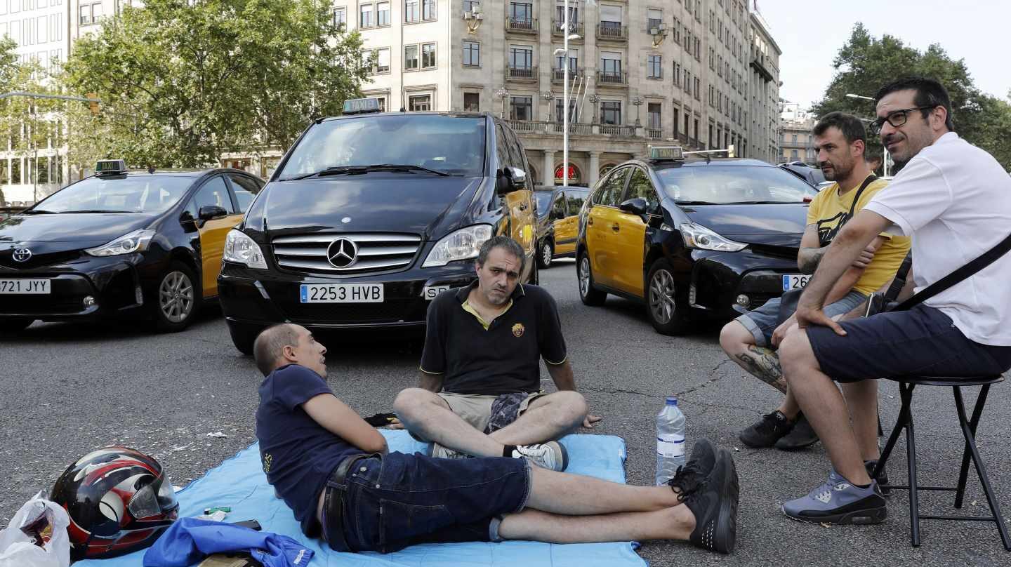 Un grupo de taxistas corta la Gran Vía de Barcelona
