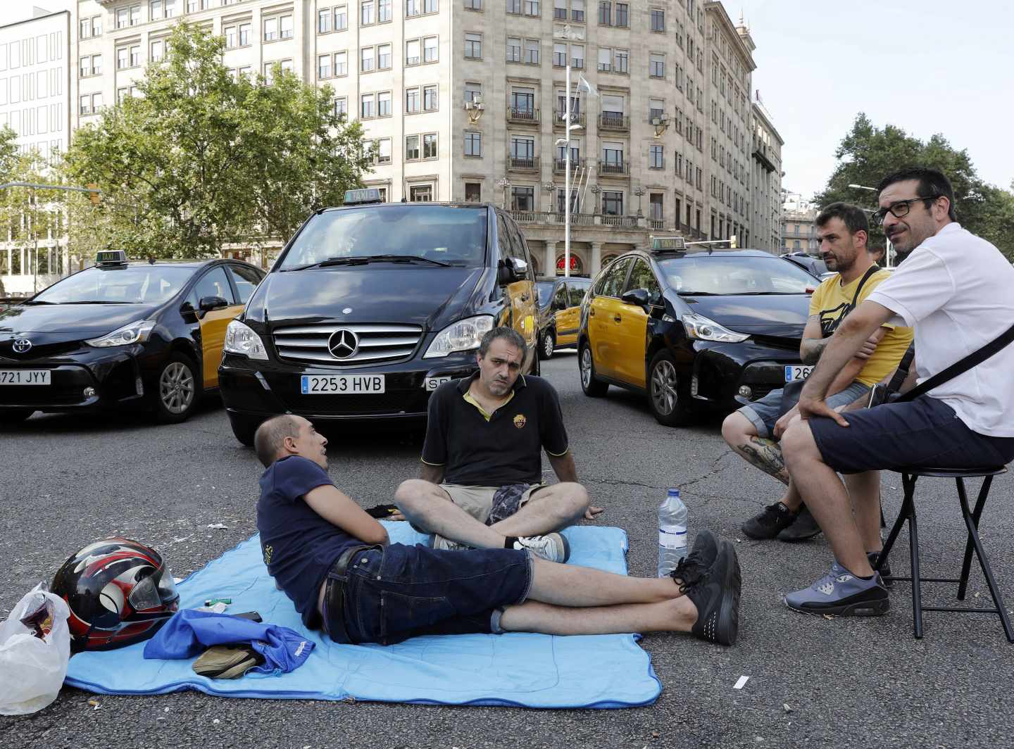 Un grupo de taxistas corta la Gran Vía de Barcelona.