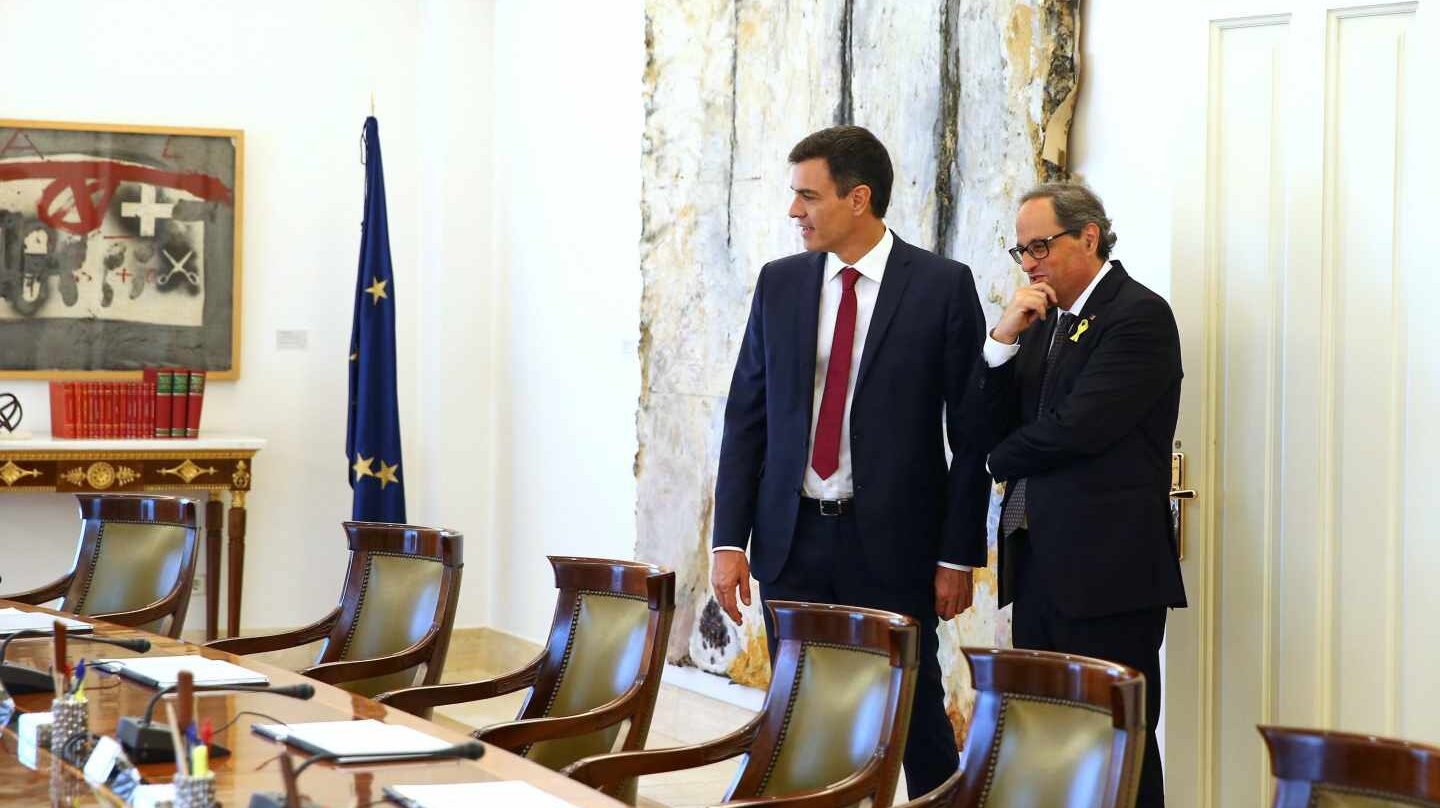El presidente del Gobierno español, Pedro Sánchez (i), muestra al presidente de la Generalitat, Quim Torra (d), el salón y la mesa del Consejo de Ministros tras la reunión mantenida hoy en el Palacio de la Moncloa