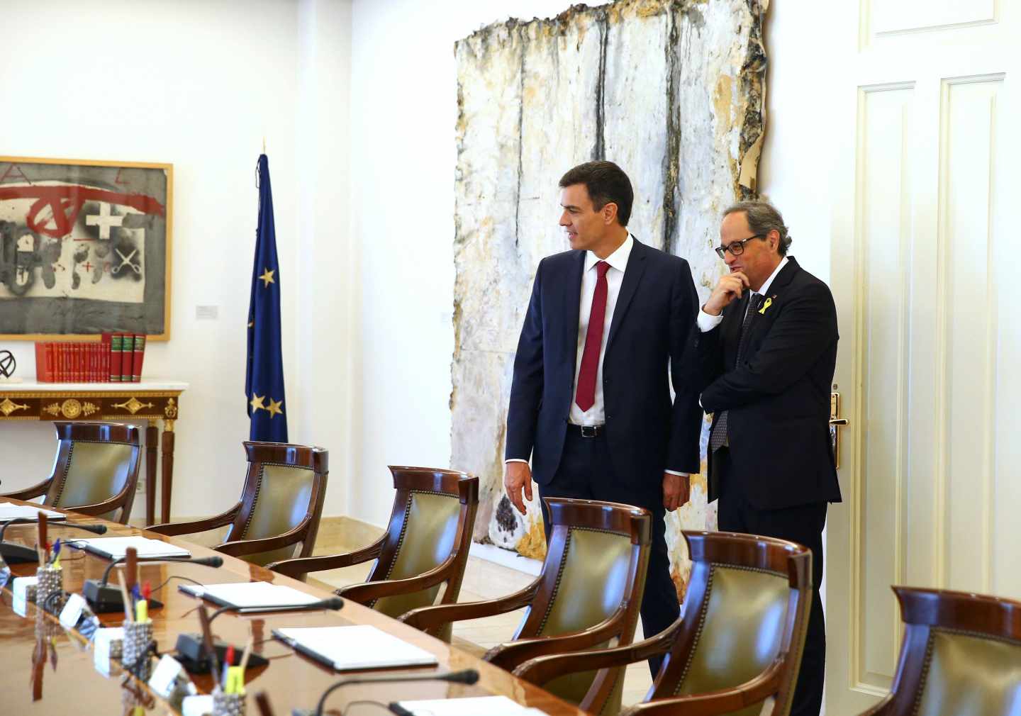 El presidente del Gobierno español, Pedro Sánchez (i), muestra al presidente de la Generalitat, Quim Torra (d), el salón y la mesa del Consejo de Ministros tras la reunión mantenida hoy en el Palacio de la Moncloa