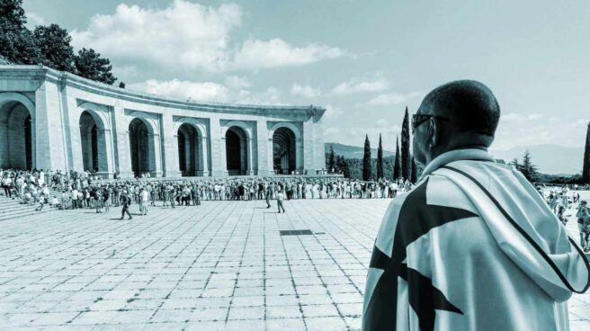 Un hombre ataviado con una capa blanca y la característica cruz roja de los caballeros del Temple observa la concentración celebrada hoy en el Valle de los Caídos, para protestar contra la intención del Gobierno de Pedro Sánchez de exhumar los restos del dictador Francisco Franco, a la que instó el pasado mes de mayo en una votación el Congreso.