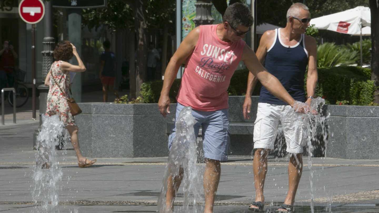 Hombre sofocando el calor en una fuente pública