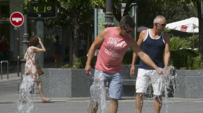 Hombre sofocando el calor en una fuente pública