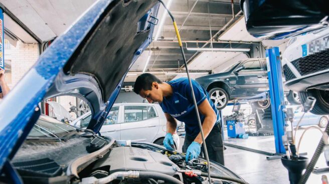 Mecánico trabajando en un taller Un mecánico trabaja en el arreglo de un coche