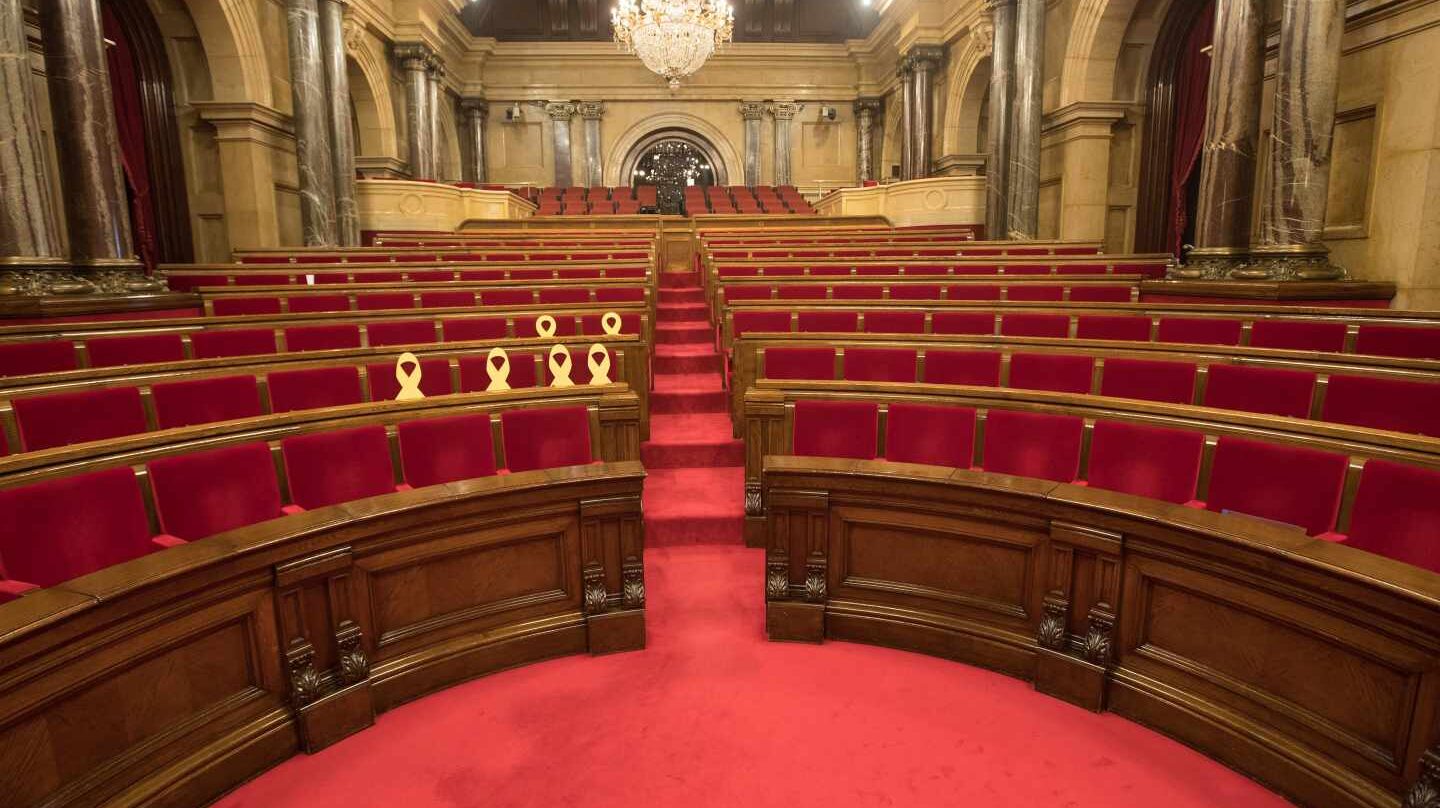 El Parlament de Cataluña, vacío y con los lazos amarillos en los escaños de los diputados huidos y encarcelados.